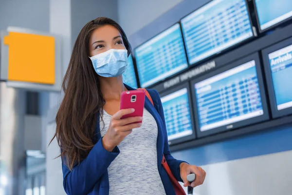 Voyage passeport femme touriste arrivant à l'aéroport en utilisant l'application de téléphone portable pour la vaccination preuve pendant les vacances pandémie de coronavirus. Asiatique fille en terminal — Photo