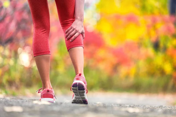 Sportblessure runner vrouw in pijn houden achterbeen kalf spier pijn van kramp tijdens trail run outdoor oefening. Ongeluk met lopende spieren. — Stockfoto