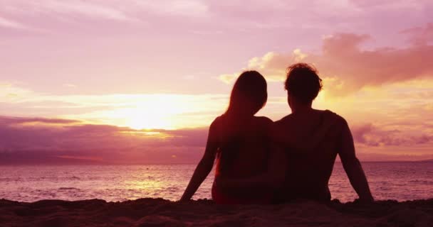 Pareja sentada romántica en la playa puesta del sol vacaciones viaje — Vídeos de Stock