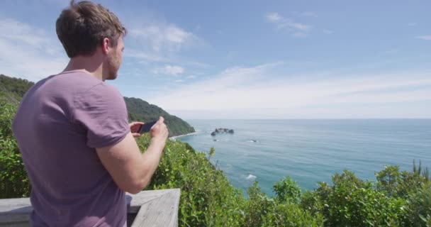 Hombre de turismo tomando fotos con teléfono inteligente en Lookout, Isla del Sur Nueva Zelanda — Vídeo de stock