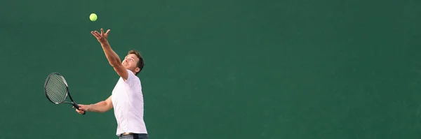 El tenis sirve durante el partido. Jugador de tenis hombre jugando a lanzar pelota en el aire que sirve jugando en la bandera panorámica de pista cubierta dura. — Foto de Stock