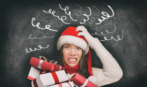 Kerststress winter winkelen cadeaus vrouw in santa hoed gestrest grappige tekeningen van hoofdpijn spiralen op zwart schoolbord banner panorama. Angst shopper te laat voor familie geschenken. — Stockfoto