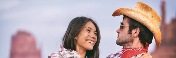 Glad leende interracial par kär. Vacker ung asiatisk kvinna skrattar åt man med cowboy hatt på USA resa, utomhus natur landskap banner — Stockfoto