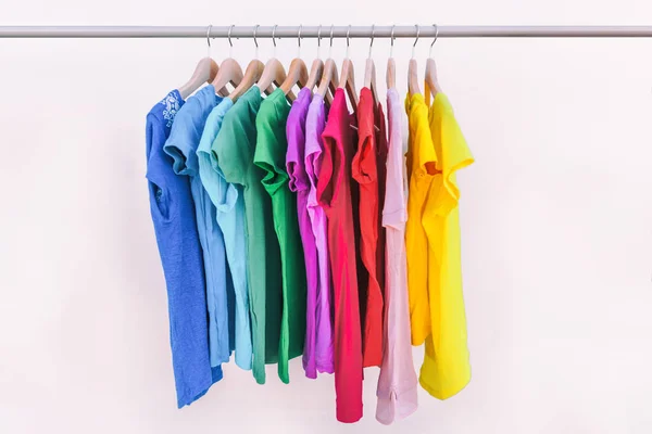 Pakaian tergantung pada pakaian rak pakaian Pakaian fashion pilihan warna pelangi t-shirt di hangers lemari. Wanita memakai di toko belanja konsep musim semi pembersihan. Lemari pakaian musim panas — Stok Foto