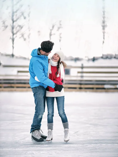 Patinaje sobre hielo actividad invernal pareja enamorada de divertirse aprendiendo a patinar en pista de patinaje con patines de alquiler. Jóvenes patinadores romántica actividad fin de semana al aire libre —  Fotos de Stock