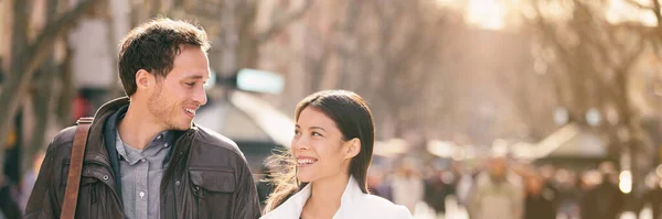 Šťastný pár zamilovat procházky v evropském městě na jarní dovolenou útěk s úsměvem na sebe panoramatické pozadí. Mladí turisté mezirasový vztah milenci banner. — Stock fotografie
