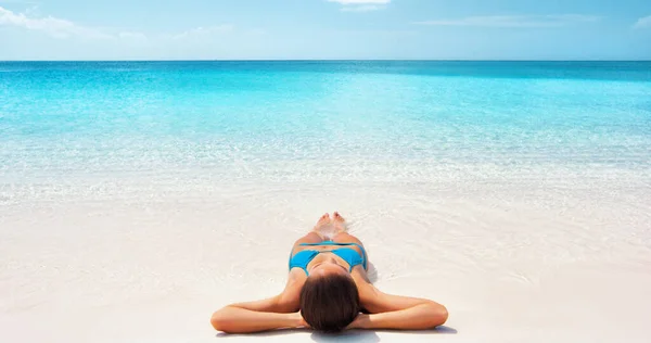 Paraíso viagem verão férias Caribe fuga biquíni mulher relaxante banhos de sol na praia de areia branca em resort de luxo com fundo azul perfeito água. — Fotografia de Stock