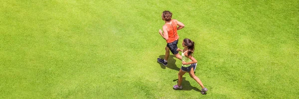 Biegacze robią ludziom baner fitness. Zdrowy, aktywny tryb życia. Aktywna para jogging razem na trawie park tło tekstury widok z góry panoramiczny baner. — Zdjęcie stockowe