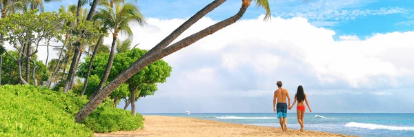 Happy couple walking on beach holiday in Hawaii, Maui island, Estados Unidos viagem de verão. Bandeira panorâmica paisagem de pessoas de trás relaxante desfrutar de férias. — Fotografia de Stock