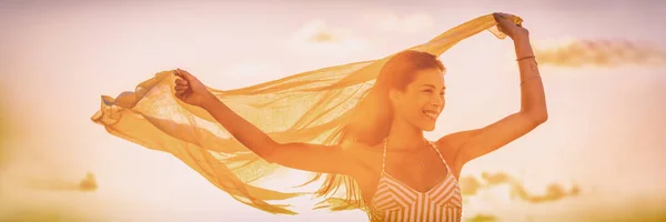 Здоровая летняя женщина, счастливая руками в свободном жёлтом шарфе, летит по ветру панорамным знамёном. Азиатская девушка в бикини для ухода за телом воск лазерная концепция. — стоковое фото
