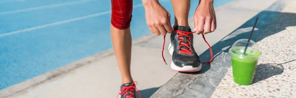 Runner przygotowuje się do uruchomienia picia zielonego soku smoothie kubek przed ćwiczeniami na torach biegowych. Sztandar panoramiczny. — Zdjęcie stockowe