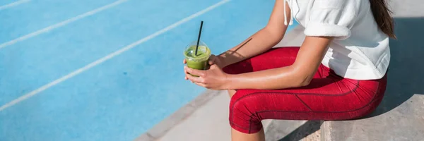 Vrouw atleet drinken van groene sap smoothie drankje in sport fitness centrum. Gezond dieet detox voedsel voor fit actieve levensstijl. Runner holding cup voor het sporten hardlopen. Panoramische banier. — Stockfoto