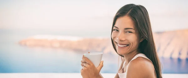 Aziatische vrouw die 's ochtends koffie drinkt tijdens het ontbijt in luxe cruise vakantie buiten restaurant op balkon met uitzicht op de Middellandse Zee, Oia Island, Griekenland. Panoramische banier. — Stockfoto