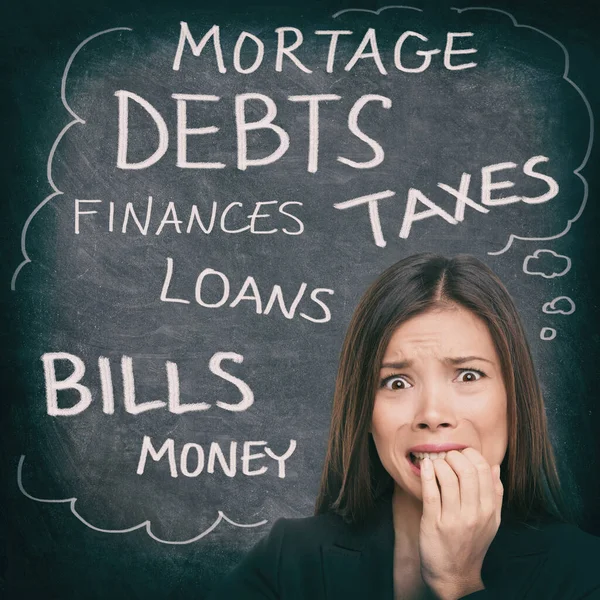 Financial stress Asian woman stressed with money problems bad credit, loans, debts, mortgage payments. Bills to pay worried person on black chalkboard with finance words written — Stock Photo, Image