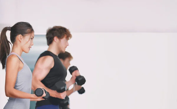 Gimnasio entrenamiento fitness personas levantando pesas en la clase de grupo de levantamiento de pesas en estudio. — Foto de Stock