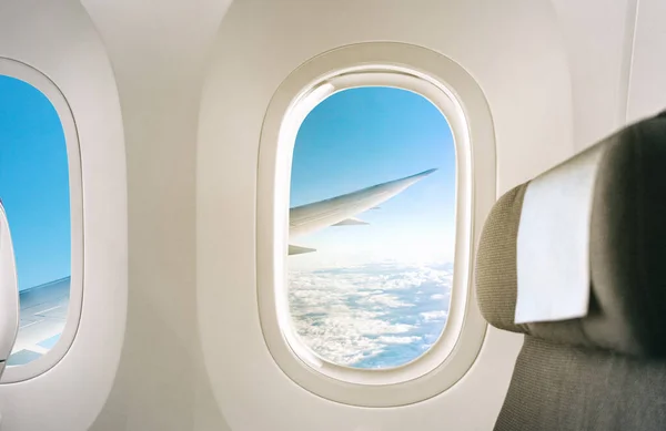 À l'intérieur d'une fenêtre plane vue de l'aile pendant le vol de l'intérieur de l'avion avec le fond du siège — Photo