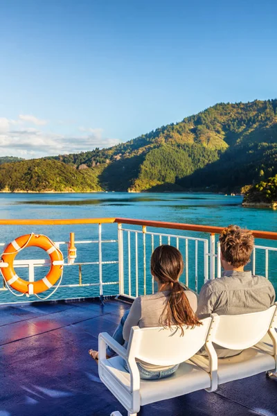 Crucero de Nueva Zelanda viaje en ferry pareja turistas relajarse disfrutando de la vista del atardecer del estrecho de Cook, Marlborough Sounds — Foto de Stock