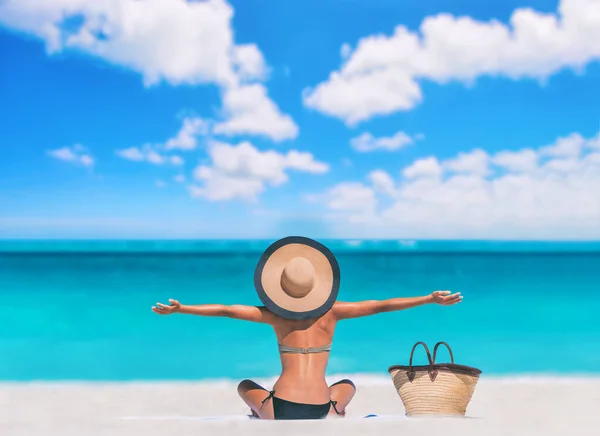 Mujer de playa feliz sin preocupaciones con los brazos abiertos en vacaciones de viaje del Caribe sol turístico bronceado tomar el sol en la toalla cuidado de la piel corporal protección contra la exposición al sol con sombrero disfrutando de vacaciones de verano. —  Fotos de Stock