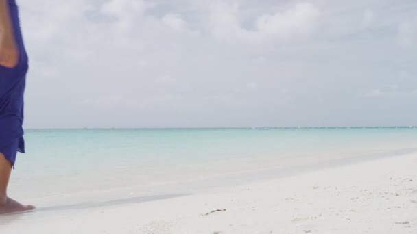 Mujer caminando en la playa tropical bajo el sol — Vídeo de stock