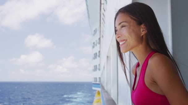 Νεαρή γυναίκα με κόκκινο φόρεμα στέκεται σε κρουαζιερόπλοιο στην ηλιόλουστη μέρα κοιτάζοντας στη θάλασσα — Αρχείο Βίντεο