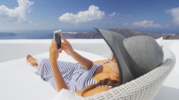 Avkopplande kvinna med hjälp av smart telefon på soffan på Resort — Stockvideo