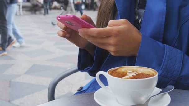 Mujer mensajes de texto en el teléfono en la cafetería al aire libre — Vídeo de stock