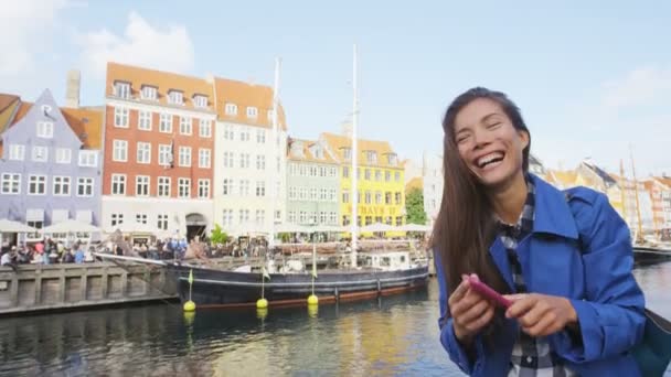 Woman laughing at Copenhagen Nyhavn using Phone — Vídeos de Stock