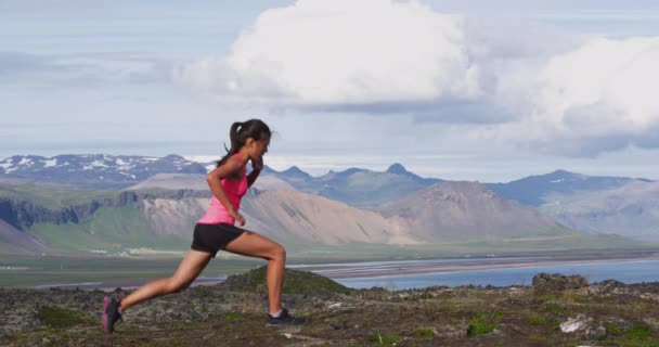 Fitness kvinna gör Pulse Lunges motion. Kvinnlig fitness modell gör Lunge Pulser träning medan du tränar på Island natur landskap träna gluten, hamstringar och quadriceps — Stockvideo