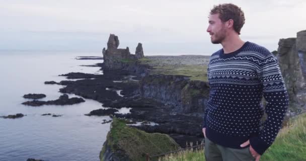 아이슬란드에서 잘 생긴 스칸디나비아 남자가 스웨터를 입고 있는 모습. 바다를 바라보고 있는 잘생긴 남성 모델입니다. ( 슬로우 모션 ) — 비디오