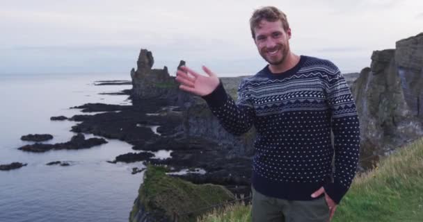 İzlanda 'da el sallayan İskandinav bir adam selam veriyor ve İzlanda' ya süveter giyerek hoş geldiniz. Okyanus kıyısına bakan yakışıklı bir erkek model. Yavaşlama Hareketi — Stok video