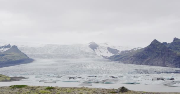 Islanda Lago glaciale della laguna di Jokulsarlon nel sud-est dell'Islanda presso il Vatnajokull National Park. Piccoli iceberg con ghiacciaio Vatnajokull sullo sfondo. SLOW MOTION — Video Stock