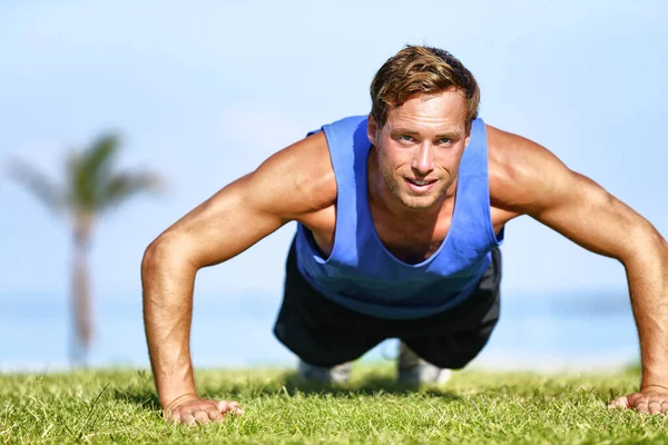 Fit man robi pompki ćwiczy trening siłowy na świeżym powietrzu na siłowni w parku. Trening zdrowy aktywny styl życia — Zdjęcie stockowe