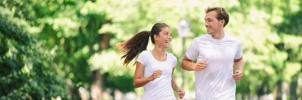 Ejecutar ejercicio amigos fitness caminar corriendo hablando juntos en la carrera de la diversión en el parque de la ciudad fondo pancarta panorámica. Vida activa saludable jóvenes, mujer asiática, pareja de hombres caucásicos —  Fotos de Stock