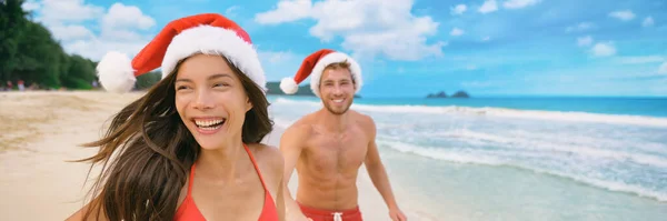 Boże Narodzenie plaża wakacje para na tropikalnych Karaibów wakacje w czerwonym Santa kapelusze panoramiczny sztandar turystów szczęśliwy na Nowy Rok zima wakacje — Zdjęcie stockowe