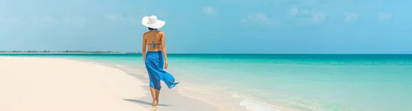 Luxury beach vacation elegant tourist woman walking relaxing in beachwear hat on white sand Caribbean beach. Lady tourist on holiday vacation resort. Banner panorama landscape — Stock Photo, Image