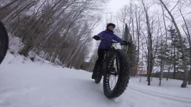 Bicicleta gorda no inverno. Mulher Biker gordo andar de bicicleta na neve na floresta de inverno. Mulher vivendo saudável ao ar livre estilo de vida ativo — Vídeo de Stock