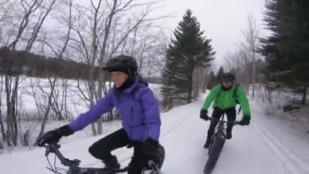 Fatbike in het winterbos. Dikke fietsers fietsen in de sneeuw in de winter. Selfie video door vrouw en man leven gezonde outdoor actieve wintersport levensstijl — Stockvideo
