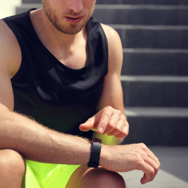 Merdivenlerde koşmadan önce spor saatine dokunan akıllı fitness adamı. Bilek ve elin yakınlığı. — Stok fotoğraf