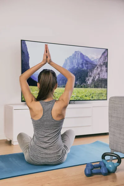 Йога на домашнем фитнес-классе потокового на ТВ приложение онлайн женщина обучение в гостиной на физкультуре мат медитации в одиночку - образ жизни тренировки — стоковое фото