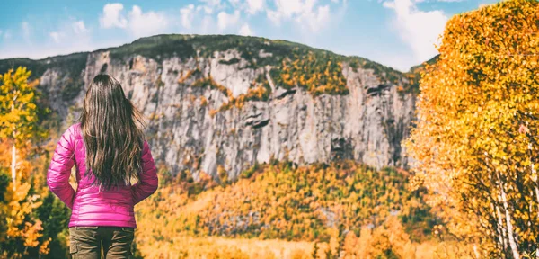 Caminata viaje otoño excursionista mujer caminando camping en Quebec Canadá bosque al aire libre con fondo de montaña. Chica senderismo con chaqueta de plumón rosa para la temporada de otoño banner paisaje escénico —  Fotos de Stock