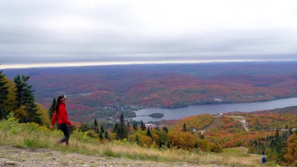 Mont Tremblant, Laurentians, Quebec, Kanada. Frau wandert auf Berg genießt Aussicht und Herbst Laub bunten Wald — Stockvideo