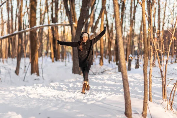 Ευτυχισμένο χειμώνα χιόνι διασκέδαση ασιατική γυναίκα παίζει έξω σε χιονόπτωση απολαμβάνοντας πτώση νιφάδες χιονιού κρύο χειμώνα σε εξωτερικούς χώρους στο δάσος της φύσης υγιεινό τρόπο ζωής των ανθρώπων. Γυναίκα που φοράει καπέλο, γάντια, παλτό — Φωτογραφία Αρχείου