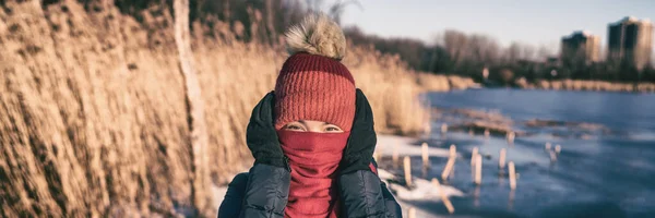 Soğuk hava, kulaklarını aksesuar eldiveni, şapka ve atkıyla kapatan soğuk panoramik pankart sahibi bir kadını koruyor. Komik açık hava faaliyet portresi — Stok fotoğraf
