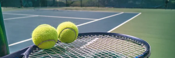 Panoramiczne tło kortu tenisowego z niebieską rakietą i dwoma piłeczkami tenisowymi gotowymi do gry na kortach zewnętrznych letni styl życia sportowego. Zdjęcie mobilne — Zdjęcie stockowe