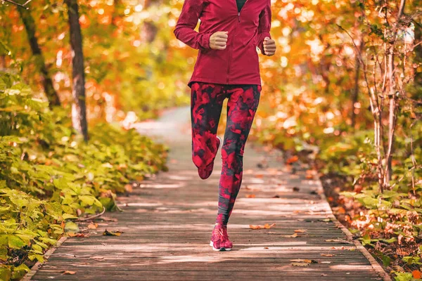 Chemin de course femme courant dans le parc forestier nature en plein air entraînement de remise en forme sur promenade à l'automne feuillage d'automne portant des vêtements de sport rouge vêtements de tenue. Fille athlète jogging extérieur — Photo