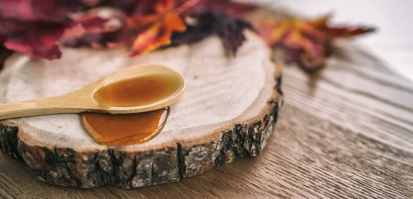 Maple syrup sugar shack cabane a sucre restaurant from Quebec farm maple tree sap famous sweet liquid dripping from wooden spoon on wood log. Rustic sugar shack banner panoramic with red leaves — Stock Photo, Image
