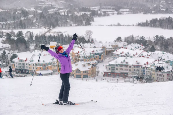 Happy skier with arms up in happiness at Mont Tremblant ski resort, Quebec, Canada. View from ski slope. Winter sports woman having fun outdoors — Stock Photo, Image