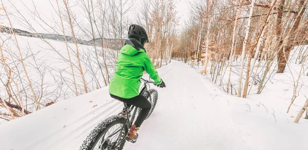 ファットバイクウィンタースポーツバイカーサイクリストバイクリングガールスノートレイルに乗っています。自然の森の中でアウトドアスポーツ背景パノラマ風景 — ストック写真