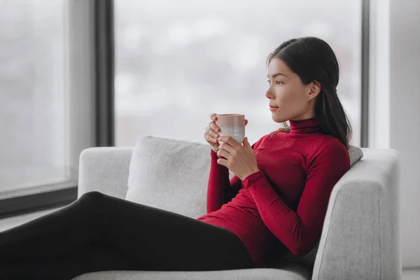 Gelukkig Aziatische vrouw ontspannen thuis tijdens coronavirus lockdown gevoel kalm en positief genieten van het drinken van koffie alleen binnen. Geestelijke gezondheid, welzijn, welzijn — Stockfoto