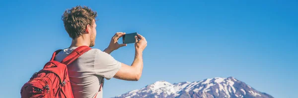 Caminante turista de viajes tomando fotos con el teléfono del paisaje de las montañas en la aventura de senderismo de verano. Banner panorámico con espacio de copia sobre fondo azul cielo —  Fotos de Stock